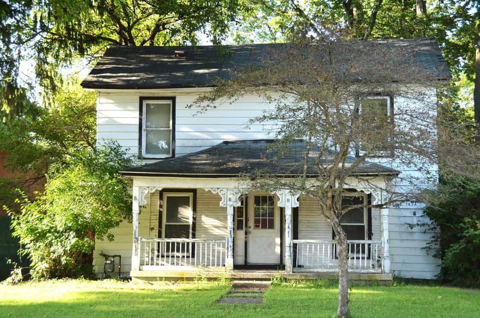 A two-storey white frame house with a front porch