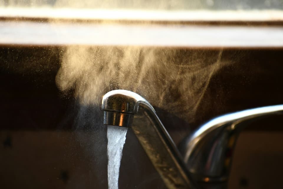 Steaming hot water running from a kitchen faucet